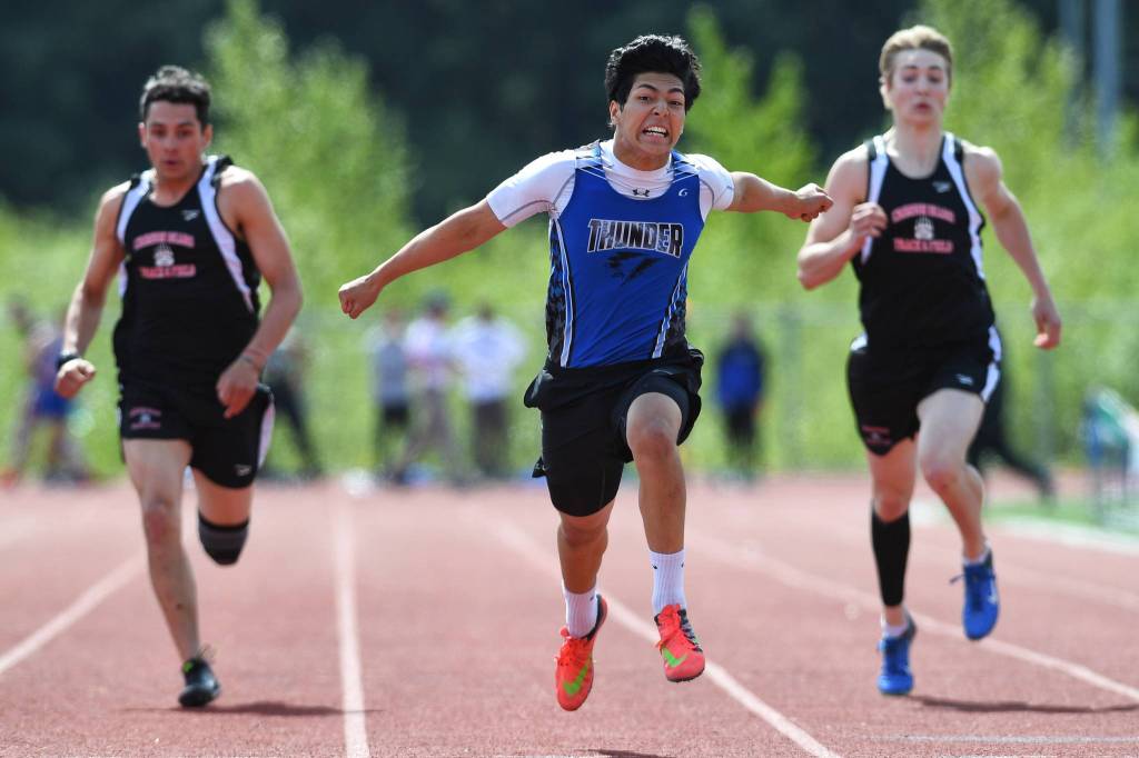Thunder Mountains Ali Beya, center, finishes in front of Juneau-Douglas Colton Johns, left, and Tyler Weldon in the 100-meter dash at the Region V Track and Field Championships at Thunder Mountain High School on Saturday, May 18, 2019. (Michael Penn | Juneau Empire)