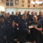 Coppa co-owner Marc Wheeler presents a check for $500 to OSC Robert Luna, head of the U.S. Coast Guard Chief Petty Officers Association in Juneau. Also present is the entire chiefs mess. (Courtesy Photo)