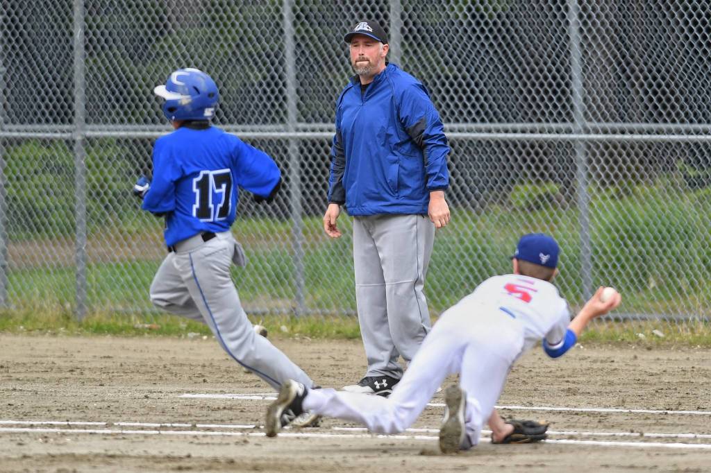 Thunder Mountains Assistant Coach Jake Carte watches as Isaiah Nelson, left, outruns the throw by Sitkas pitcher Cole Riggs during the Region V Baseball Championship at Adair-Kennedy Memorial Park on Friday, May 24, 2019. (Michael Penn | Juneau Empire)