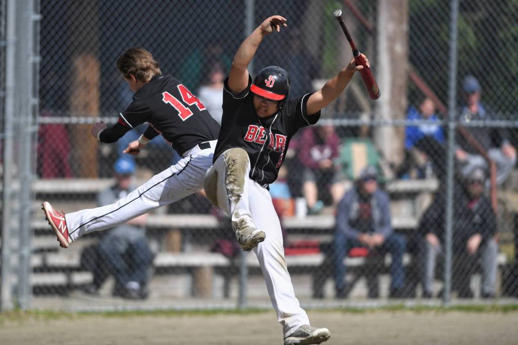 Juneau-Douglas Kona Ogoy, right, celebrates with teammate Austin McCurley after scoring the go-ahead run in the seventh inning against Ketchikan during the Region V Baseball Championship at Adair-Kennedy Memorial Park on Friday, May 24, 2019. (Michael Penn | Juneau Empire)