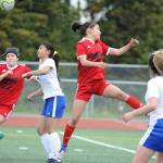 Juneau-Douglas Blake Plummer, right, leaps for a corner kick as teammate Nikki Box looks on and Kodiak defenders Jasmine Leiva (2) and Kyla Quiambao help defend at the ASAA/First National Bank Alaska soccer state championships at Service High School in Anchorage on Thursday, May 23, 2019. JDHS won 6-0. (Michael Dinneen | For the Juneau Empire)
