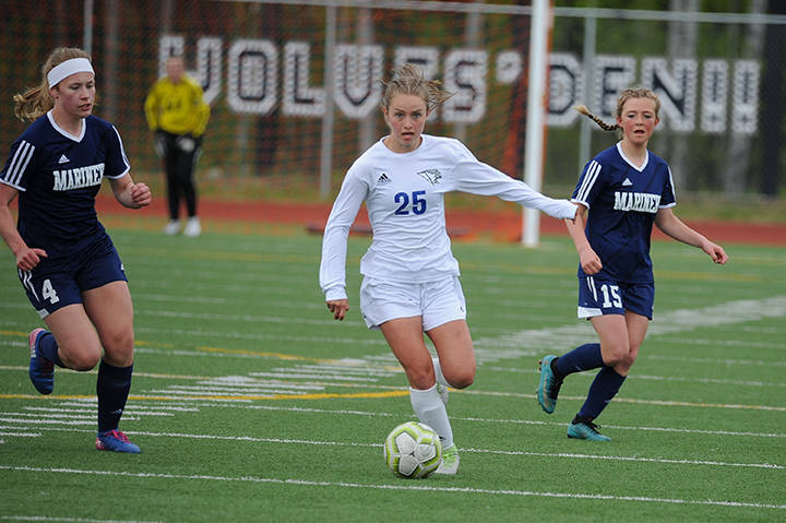 Thunder Mountains Kiah Dihle dribbles between Homer defenders Jessica Sonnen, left, and Sela Weisser during the ASAA/First National Bank Alaska soccer state championships at Eagle River High School on Thursday, May 23, 2019. TMHS won 1-0. (Michael Dinneen | For the Juneau Empire)