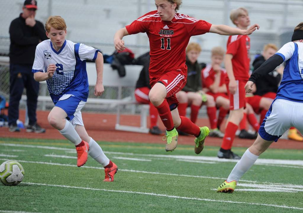 Juneau-Douglas Jackson Norberg flies to the ball between Palmers Duncan Hetrick, left and Ian Roberts during the first half of their ASAA/First National Bank Alaska soccer state championship match Thursday evening at Service High School in Anchorage. (Michael Dinneen | For the Juneau Empire)