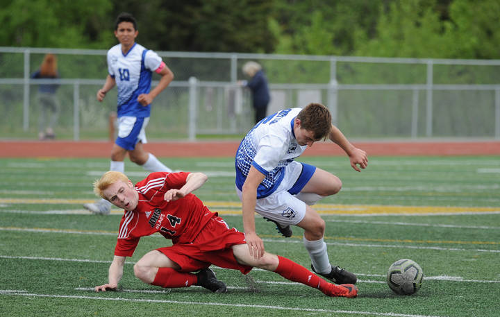 Juneau-Douglas Kanon Goetz is upended by Palmers Michael Lovejoy in the first half of their ASAA/First National Bank Alaska soccer state championship match Thursday evening at Service High School in Anchorage. (Michael Dinneen | For the Juneau Empire)