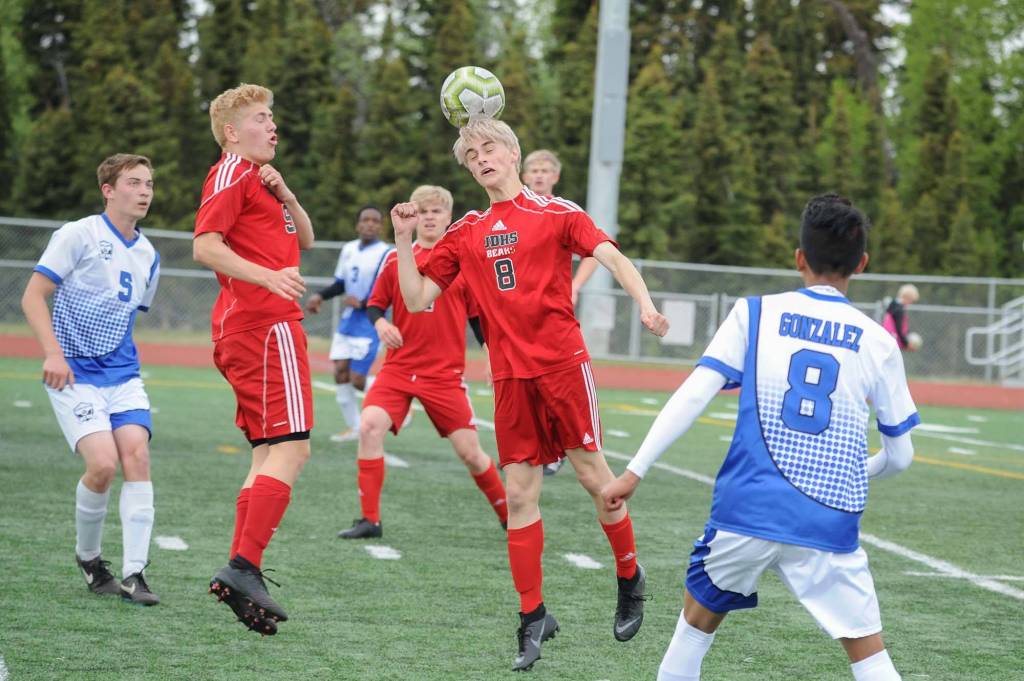 Juneau-Douglas Koby Goldstein, center, heads the ball as teammate Richard Lehner looks on during the first half of their ASAA/First National Bank Alaska soccer state championship match Thursday evening at Service High School in Anchorage. For Palmer are Makeehan Knittle, left and Pedro Gonzalez. (Michael Dinneen | For the Juneau Empire)