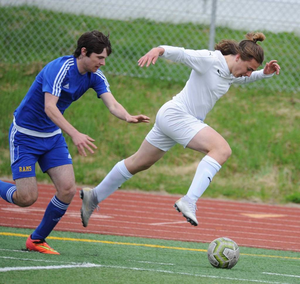 Thunder Mountains Gavin Gende is helped through the air by an unidentified Monroe Catholic player during the first half of their ASAA/First National Bank Alaska soccer state championship match Thursday evening at Service High School in Anchorage. (Michael Dinneen | For the Juneau Empire)
