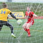 Juneau-Douglas Eva Goering scores past Kodiak goalie Annora Virgin during their ASAA/First National Bank Alaska soccer state championship match Thursday afternoon at Service High School in Anchorage. (Michael Dinneen | For the Juneau Empire)