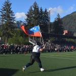 Juneau Stars Lino Fenumiai, a graduate of 2000, enters the field for the Juneau Alumni Football Game with football players, dance team members and cheerleaders from Juneau-Douglas and Thunder Mountain High Schools at Adair-Kennedy Memorial Field on Friday, May 24, 2019. (Michael Penn | Juneau Empire)