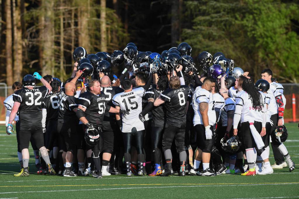 Players from both teams meet at midfield for the Juneau Alumni Football Game with football players, dance team members and cheerleaders from Juneau-Douglas and Thunder Mountain High Schools at Adair-Kennedy Memorial Field on Friday, May 24, 2019. (Michael Penn | Juneau Empire)