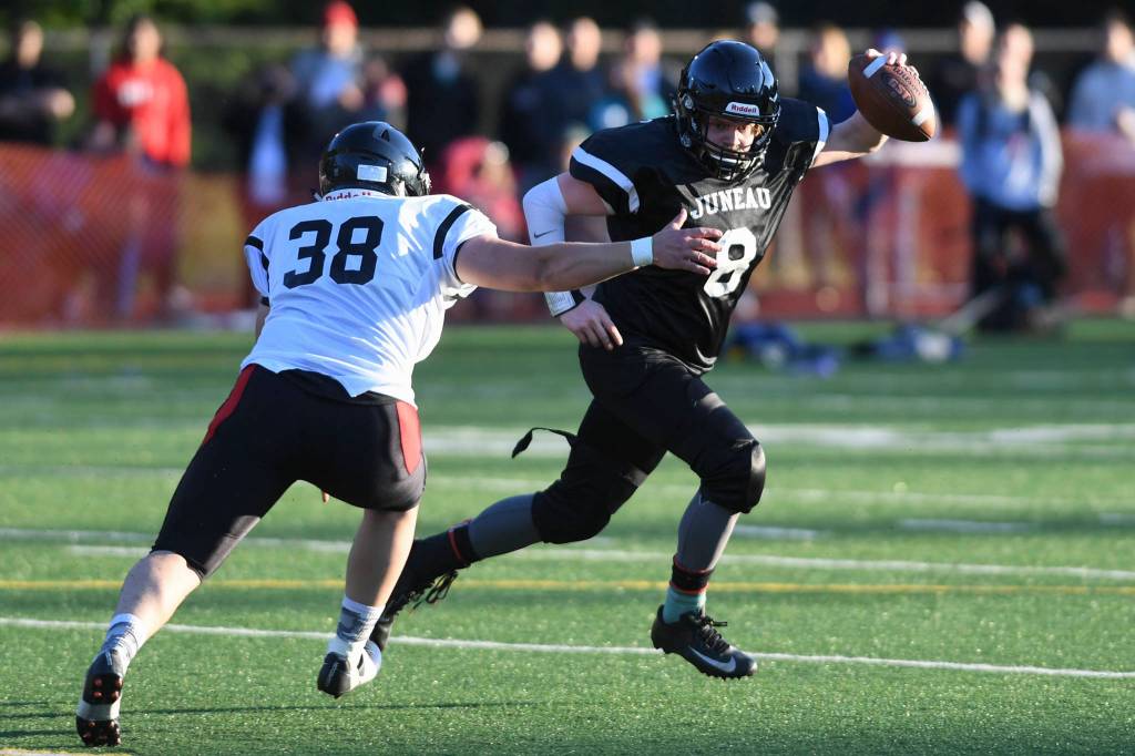 Legends Stefan Jones, right, is pursued by Stars Dylan Skrzynski in the Juneau Alumni Football Game with football players, dance team members and cheerleaders from Juneau-Douglas and Thunder Mountain High Schools at Adair-Kennedy Memorial Field on Friday, May 24, 2019. (Michael Penn | Juneau Empire)