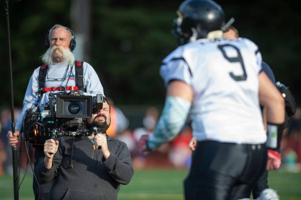 A video crew from NFL Films documents the Juneau Alumni Football Game with football players, dance team members and cheerleaders from Juneau-Douglas and Thunder Mountain High Schools at Adair-Kennedy Memorial Field on Friday, May 24, 2019. (Michael Penn | Juneau Empire)