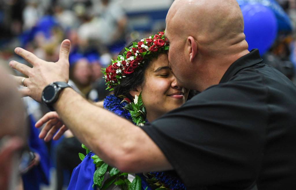 Kaili DeMello receives a kiss from her father, Jeremy, after the Thunder Mountain High School graduation on Sunday, May 26, 2019. (Michael Penn | Juneau Empire)