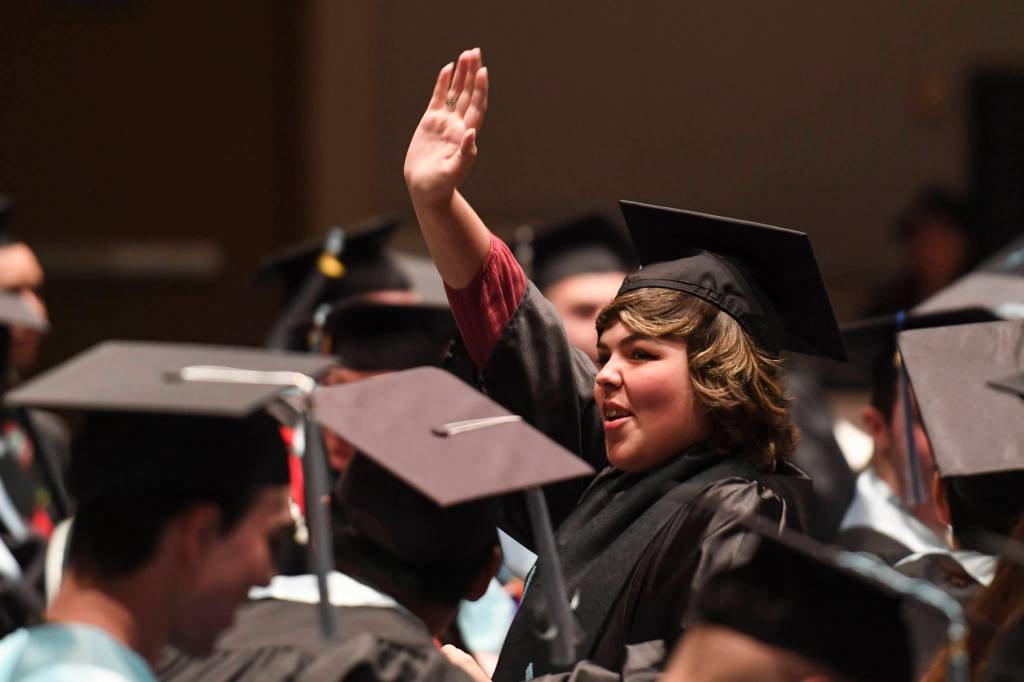Shayla Woodbury waves to family during the Yaakoosgé Daakahidi High School graduation ceremony at Centennial Hall on Sunday, May 26, 2019. (Michael Penn | Juneau Empire)