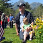 Jim Asper holds his grandson, Jim Reeder, 1, at Evergreen Cemetery during a Memorial Day ceremony the morning of Monday, May 27. (Ben Hohenstatt | Juneau Empire)