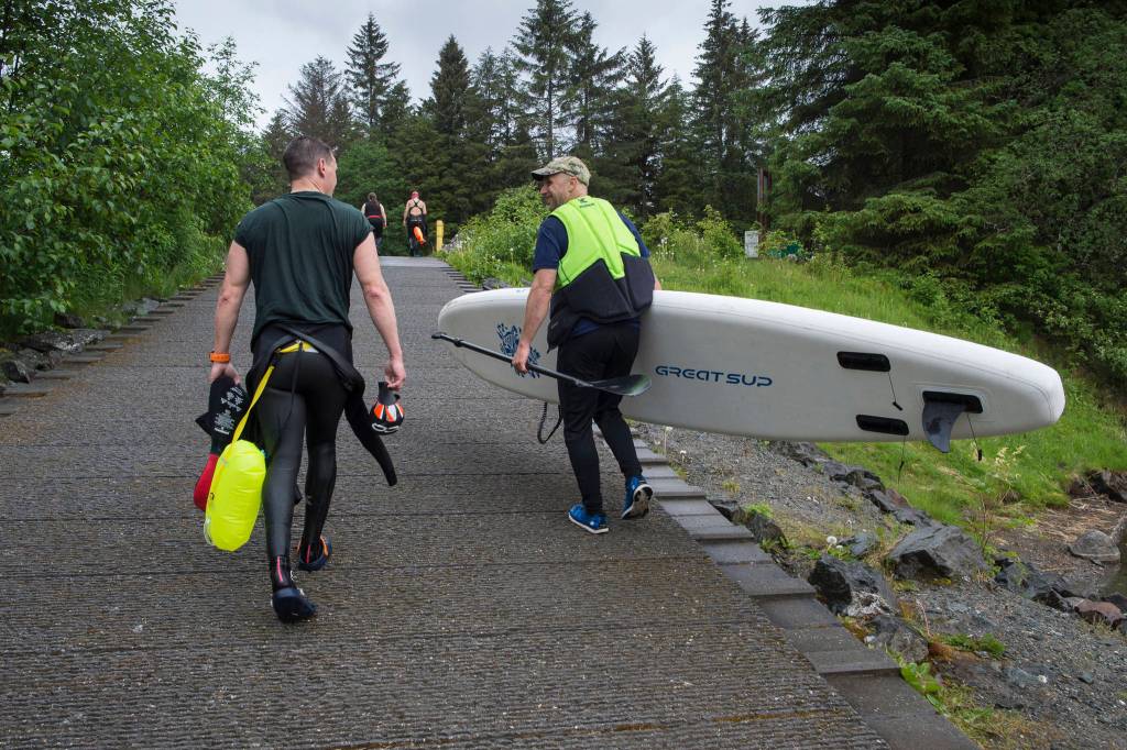 Scott Gende, left, and Kevin Sellers head up the ramp after swimmers trained in Auke Lake on Wednesday, June 5, 2019. (Michael Penn | Juneau Empire)