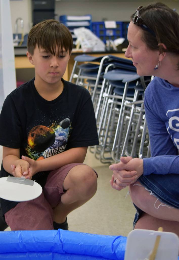 Fischer Kolodziejski, 8, fans his boat while mom, Bobbie Joe Skibo, looks on during the Camp Invention showcase at Thunder Mountain High School, Friday, June 7, 2019. (Ben Hohenstatt | Juneau Empire)