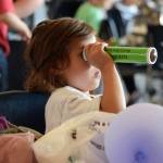 Kaelynn Beedle, 5, looks into a kaleidoscope during the Camp Invention showcase at Thunder Mountain High School, Friday June 7, 2019. (Ben Hohenstatt | Juneau Empire)
