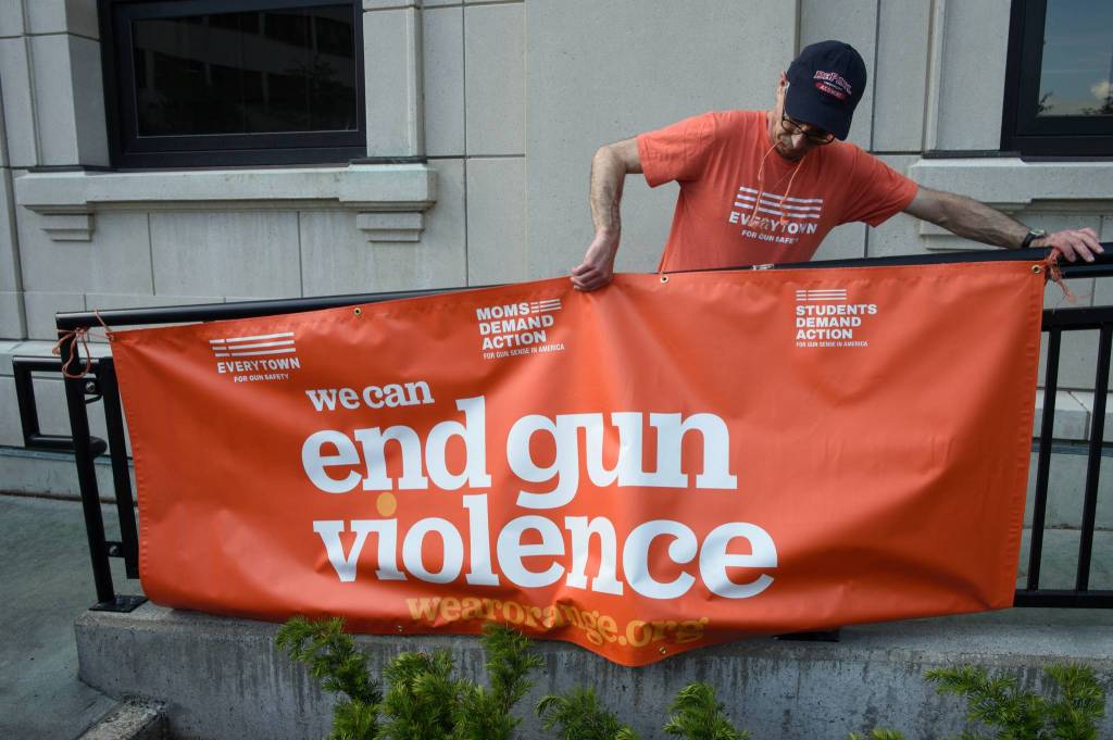John Sonin ties up a sign at the Capitol for National Gun Violence Awareness Day rally on Friday, June 7, 2019. (Michael Penn | Juneau Empire)