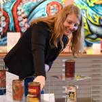 Anjuli Grantham shows off historic salmon canneries tin from a collection from the Karen Hofstad at the Alaska State Librarys Research Center for First Friday on Friday, June 7, 2019. (Michael Penn | Juneau Empire)