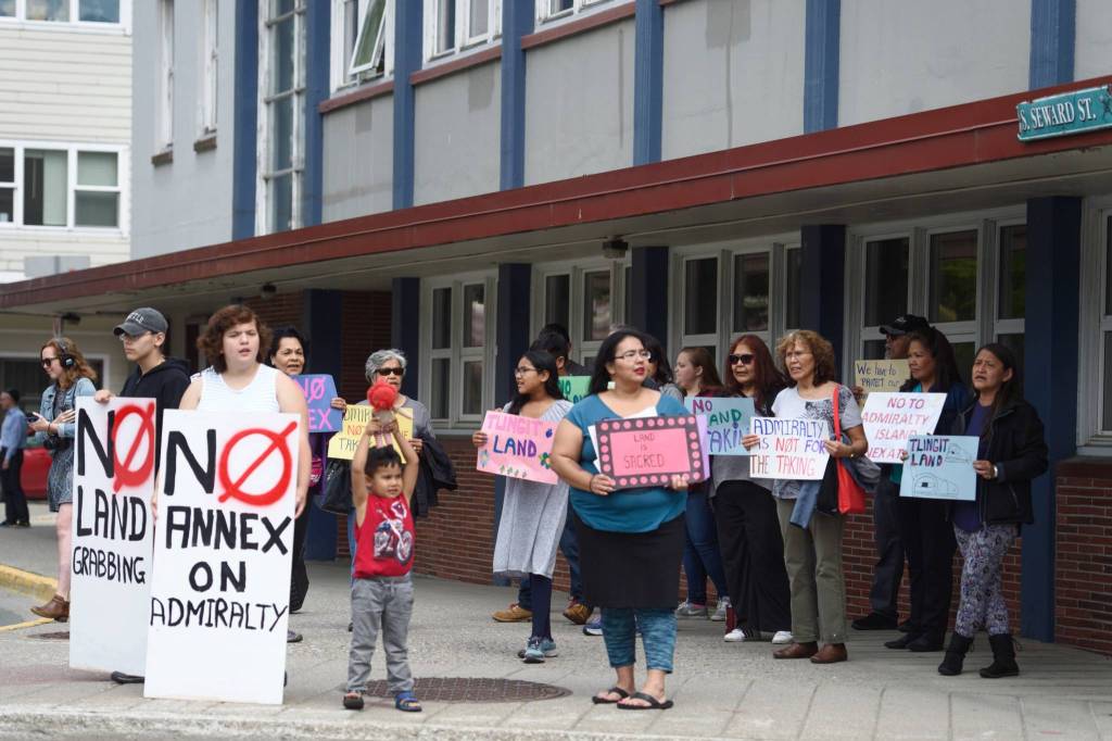 Protesters against City and Borough of Juneaus proposed annexation of land on Admiralty Island hold signs out of the City and Borough of Juneau City Hall Friday, June 14, 2019. (Ben Hohenstatt | Juneau Empire)