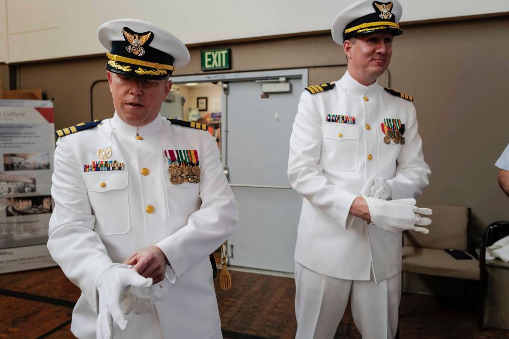 U.S. Coast Guard Commander Andrew S. Joca, left, and Commander Nathan L. Rumsey don their white gloves before a Change of Command ceremony at the Juneau Arts and Culture Center on Thursday, June 20, 2019. Outgoing Commander Joca assumed command of the Civil Engineering Unit in Juneau in May 2016 and will become the Director of Operational Logistics in Norfolk, Virginia. Commander Rumseys most recent assignment was the Engineer Officer and Facilities Engineer at Sector New York. (Michael Penn | Juneau Empire)