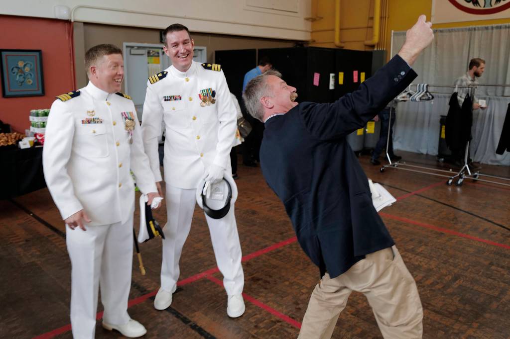 Mark Ridgway, right, takes a selfie with both commanders after the ceremony. (Michael Penn | Juneau Empire)