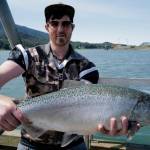 Alexander Masters displays his freshly caught king salmon at the Wayside Park on Channel Drive on Thursday, June 20, 2019. (Michael Penn | Juneau Empire)