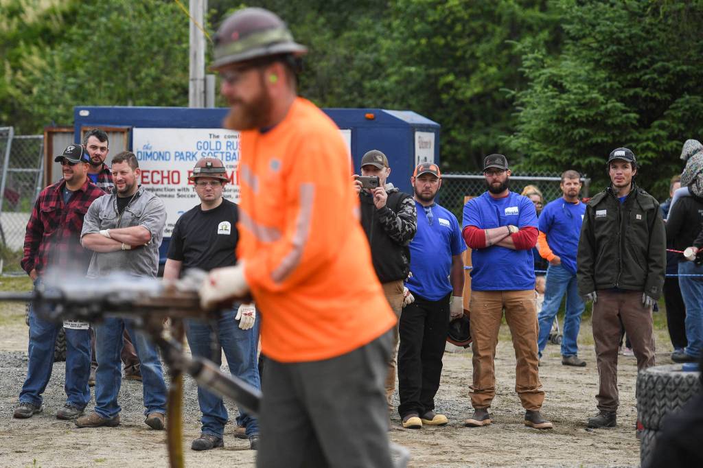 Contestants watch Trevar Haus in the jackleg drilling contest during the Mining & Logging Competition at the 29th Annual Gold Rush Days at Savikko Park on Saturday, June 22, 2019. (Michael Penn | Juneau Empire)