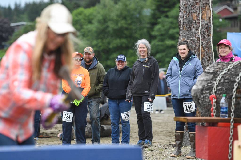 Contestants watch April Hoy in the spike driving contest during the Mining & Logging Competition at the 29th Annual Gold Rush Days at Savikko Park on Saturday, June 22, 2019. (Michael Penn | Juneau Empire)