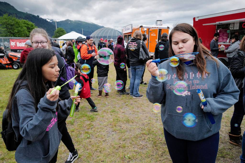 Chloe Vonta, 15, left, and Brianna Elisoff, 14, entertain themselves making soap bubbles at the 29th Annual Gold Rush Days at Savikko Park on Saturday, June 22, 2019. (Michael Penn | Juneau Empire)