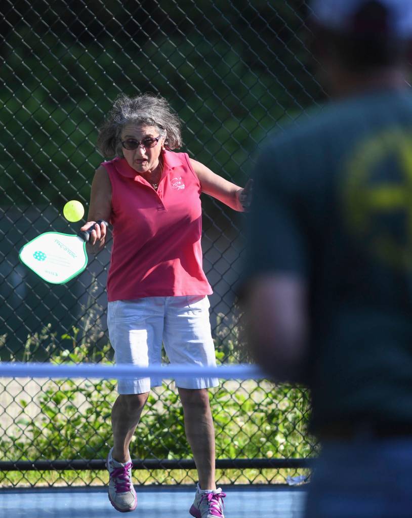 Orlinda Kittredge plays the ball during a pickleball match at the Cope Park tennis courts on Wednesday, June 26, 2019. (Michael Penn | Juneau Empire)