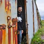 Chris Peloso peaks out from behind a rusted door during a trip to Adak. Photos from that trip will be part of the Im Lost here w/o you exhibition at Devils Club Brewing Co. (Courtesy Photo | Chris Peloso)