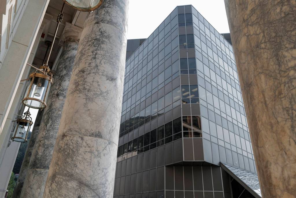 The marble pillars of the Alaska State Capitol are contrasted against the steel and glass of the Dimond Courthouse on Tuesday, July 2, 2019. The pillars, quarried in Tokeen, Alaska, will be sealed and ground smooth as part of the buildings remodeling project. (Michael Penn | Juneau Empire)