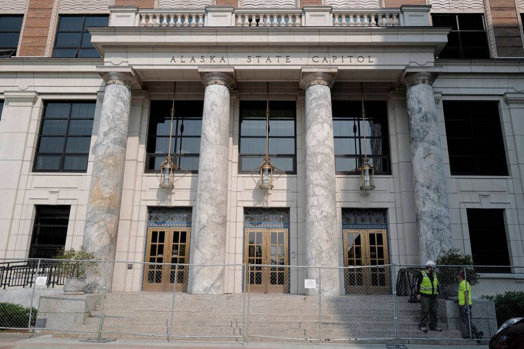 Fencing is installed in front of the Alaska State Capitol on Tuesday, July 2, 2019. The marble pillars, quarried in Tokeen, Alaska, will be sealed and ground smooth as part of the buildings remodeling project. (Michael Penn | Juneau Empire)