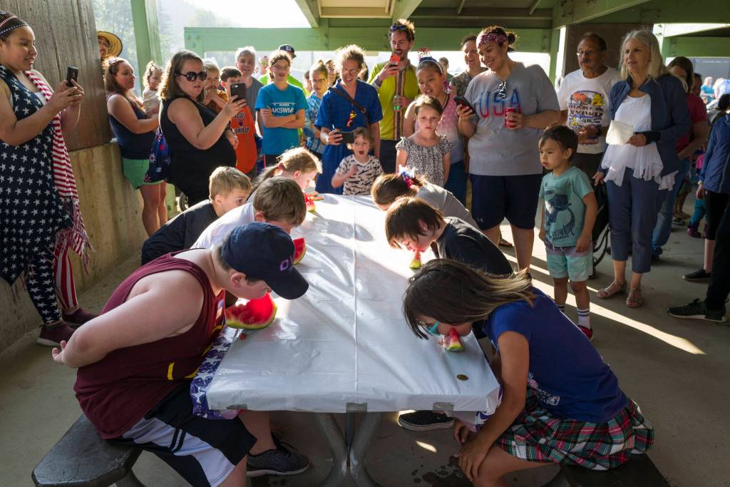 Children participate in a watermelon eating contest during a community picnic sponsored by the Douglas Fourth of July Committee and Capital City Fire/Rescue at Sandy Beach on Wednesday, July 3, 2019. (Michael Penn | Juneau Empire)