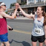 Beth Gollin, right, receives a high five from Drew Stafford after she was the first woman to finish the Glenn Frick Memorial Mile on Thursday, July 4, 2019. (Michael Penn | Juneau Empire)