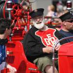 Mike Race, center, rides in a 1937 Ford Fire Engine during the Juneau Fourth of July Parade on Thursday, July 4, 2019. Race was a volunteer fireman for 18 years. (Michael Penn | Juneau Empire)