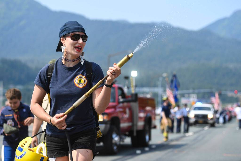 Meghan DeSloover of Capital City Fire/Rescue keeps poeple cool during the Juneau Fourth of July Parade on Thursday, July 4, 2019. (Michael Penn | Juneau Empire)