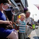 Lisa and Joshua Adams watch their son, Erik, 2, make soap bubbles during the Juneau Fourth of July Parade on Thursday, July 4, 2019. (Michael Penn | Juneau Empire)