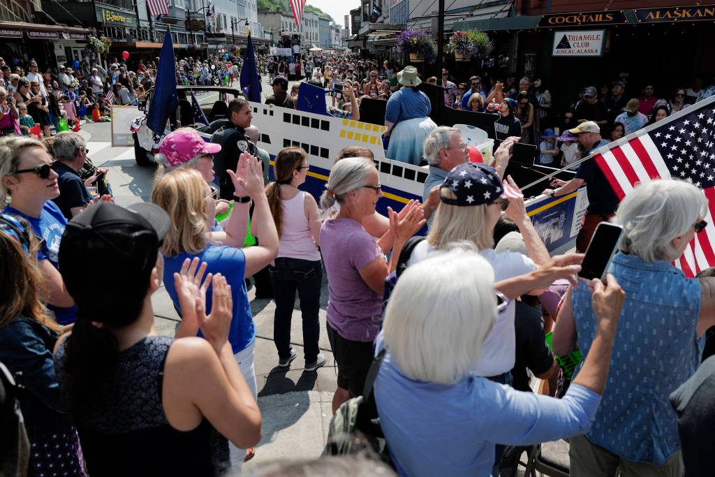 People applaud as a Alaska Marine Highway System float goes by during the Juneau Fourth of July Parade on Thursday, July 4, 2019. (Michael Penn | Juneau Empire)