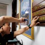 Ron Lumba, of the Alaska State Capitols maintenance staff, adds the Majority Leader plate to the front of the office of Sen. Lyman Hoffman, D-Bethel, on the first day of the Second Special Session of the Alaska Legislature in Juneau on Monday, July 8, 2019. (Michael Penn | Juneau Empire)