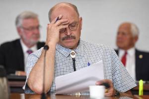 Senate Finance member Sen. Click Bishop, R-Fairbanks, center, studies the FY20 Budget during a Senate Finance Committee meeting at the Capitol on Tuesday, July 9, 2019. Sen. Gary Stevens, R-Kodiak, left, and Sen. Chris Birch, R-Anchorage, right, listen in the background. (Michael Penn | Juneau Empire)