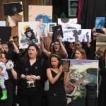 About 50 artists stand with their work in front of the Sealaska Heritage Institute on Tuesday, July 9, 2019, to protest heavy cuts to state arts programs. (Michael Penn | Juneau Empire)