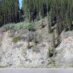 Two boaters on the Yukon River cross from the Yukon into Alaska on July 5. The border is marked by a 20-foot clearing and a metal obelisk. (Courtesy Photo | Ned Rozell)