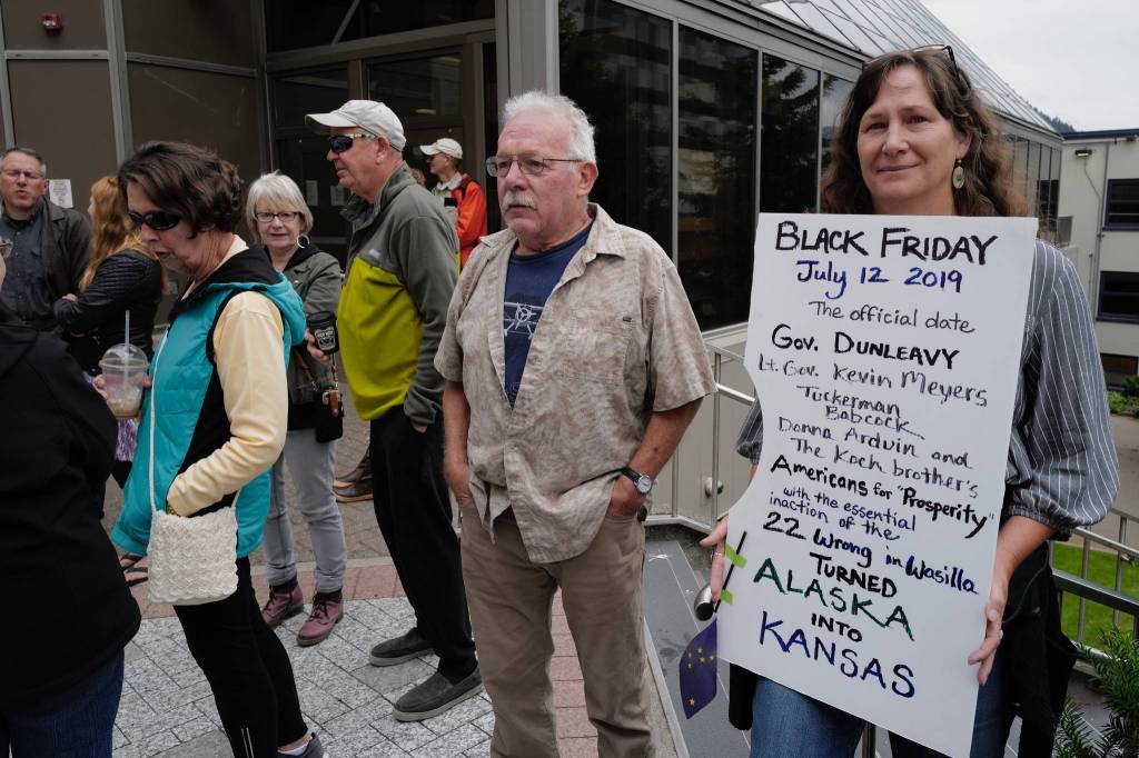 Sarah Dunlap holds her Black Friday sign at a rally against Gov. Mike Dunleavys budget vetoes in front of the Capitol on Friday, July 12, 2019. (Michael Penn | Juneau Empire)