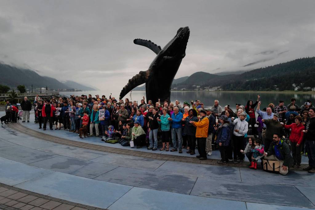 A crowd denouncing immigrant detention facilities pose for a picture at Mayor Bill Overstreet Park, Friday, July 12, 2019. (Michael Penn | Juneau Empire)