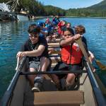 In this photo taken June 20, 2019, Tyler Henderson, left, and Sitka Atkinson paddle a Tsimshian war canoe past a cluster of sunken boats during Culture Camp near Hemlock Island and Metlakatla, Alaska. This year was the first time the Ketchikan Indian Community and Nüüm Na Waalt culture camps joined together for the event and a seven-night campout on the island. (Dustin Safranek/Ketchikan Daily News via AP)