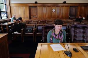 Alyson Currey gives testimony on HB 2001 in the House Finance Committee room as Marc Wheeler, left, waits his turn at the Capitol on Tuesday, July 16, 2019. The committee is meeting in Wasilla and taking testimony telephonically from around the state. (Michael Penn | Juneau Empire)