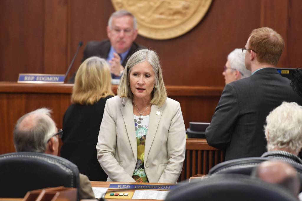 Rep. Andi Story, D-Juneau, center, talks with House Majority Leader Steve Thompson, R-Fairbanks, during a break in a House session at the Capitol on Wednesday, July 24, 2019. (Michael Penn | Juneau Empire)