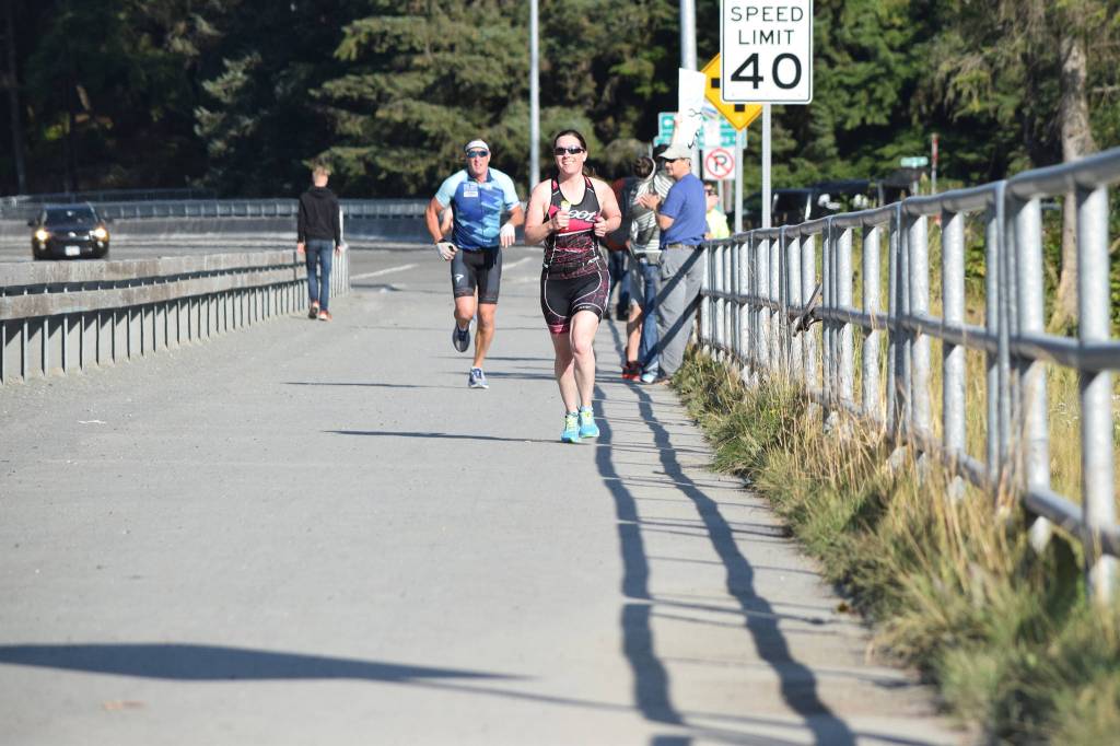 Kim Campbell runs past Auke Lake while competing in 2019 Aukeman Triathon on Saturday, Aug. 3, 2019. (Nolin Ainsworth | Juneau Empire)